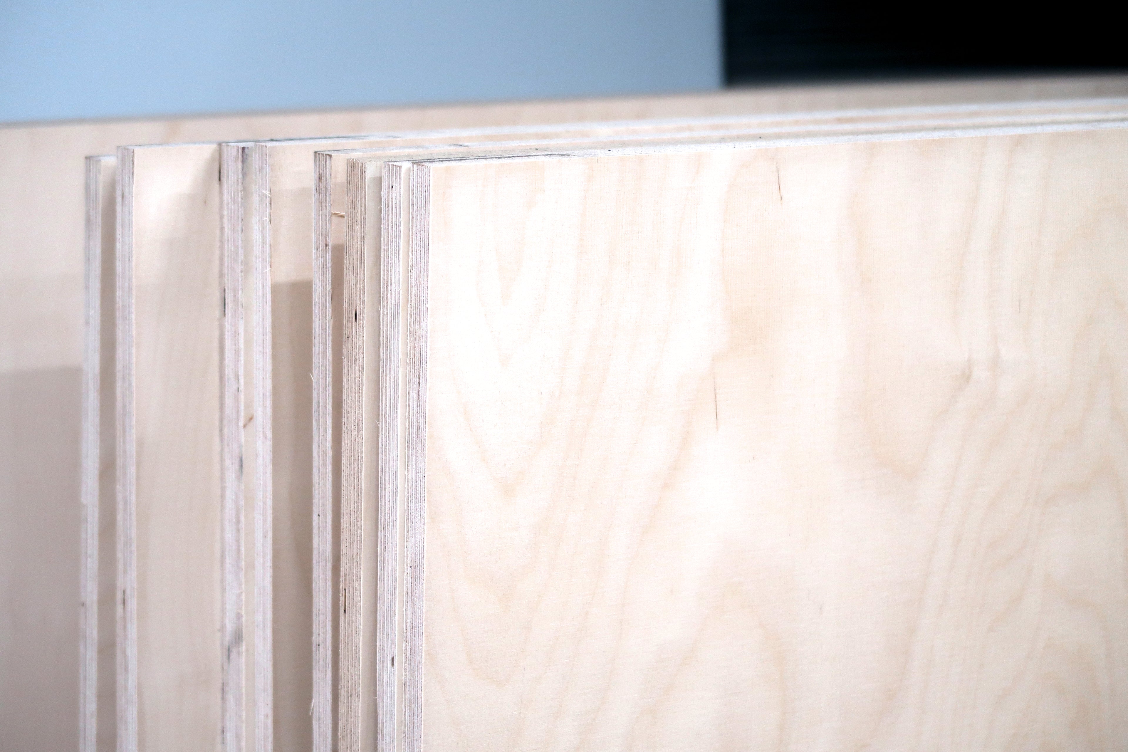 Close-up of smooth layered plywood sheets stacked, highlighting robust and modular wood design quality.