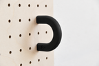 Black size M coloured ring on a birch pegboard