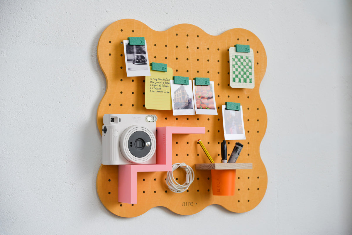 Pot à crayons suspendu orange sur pegboard Art Studio
