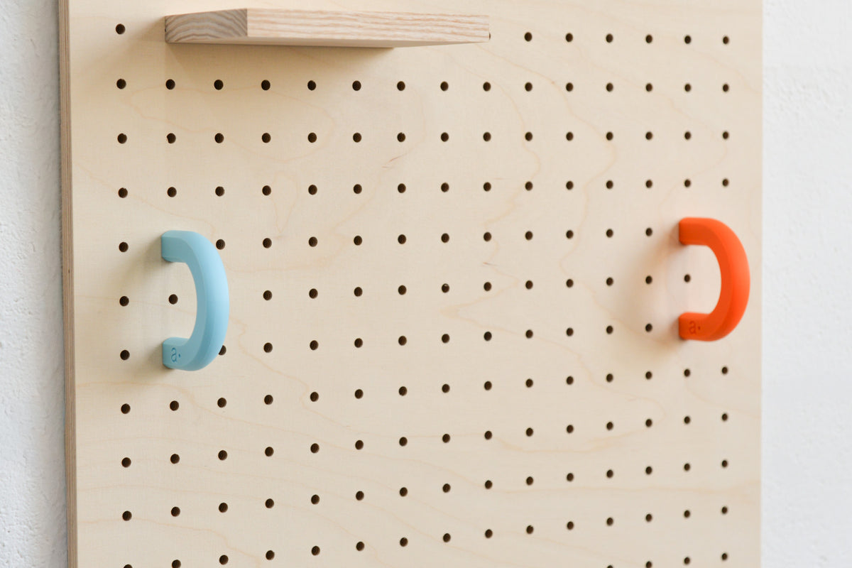 Sky blue and orange coloured rings on a birch pegboard