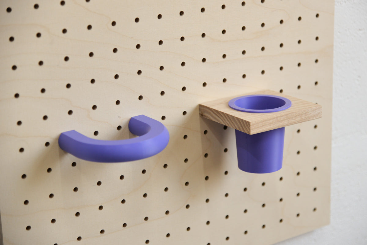 Purple coloured ring on a birch pegboard, next to a purple hanging pot