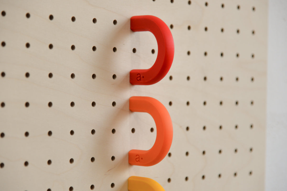 Red and orange coloured rings on a birch perforated panel