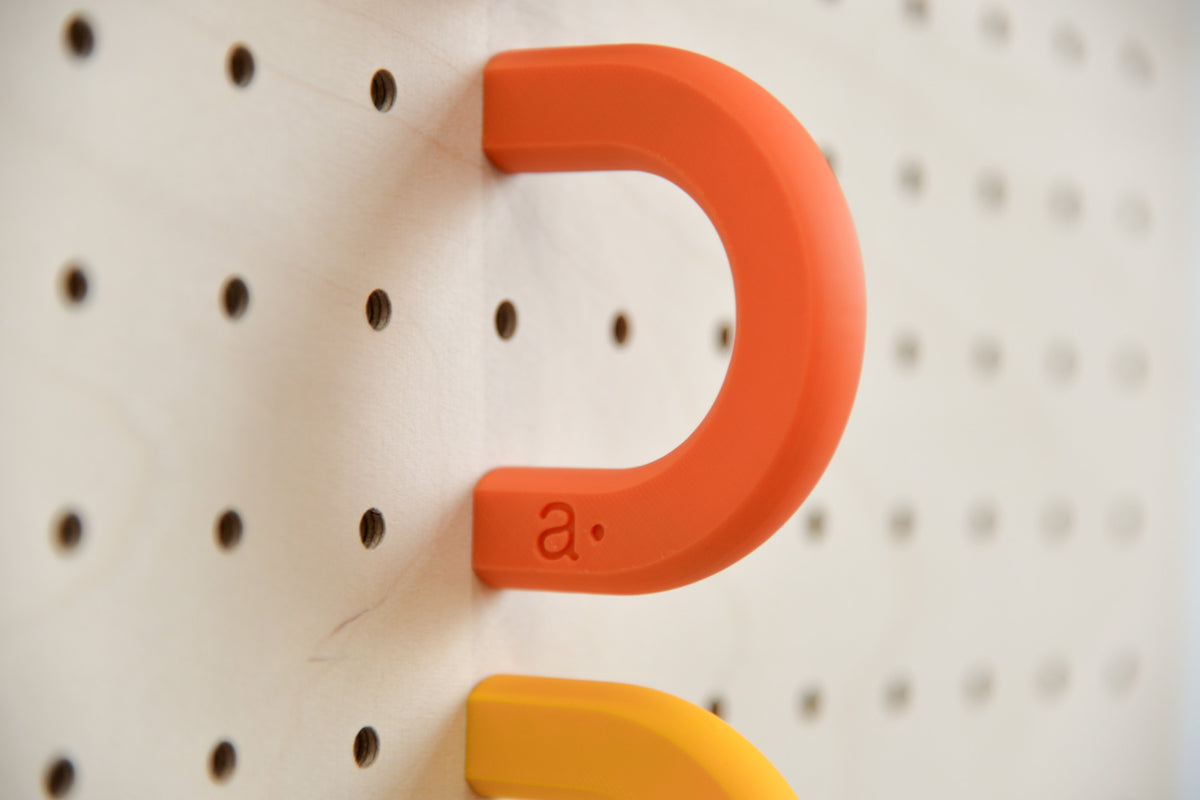 Gros plan sur l'anneau coloré orange pour pegboard avec le logo Aire