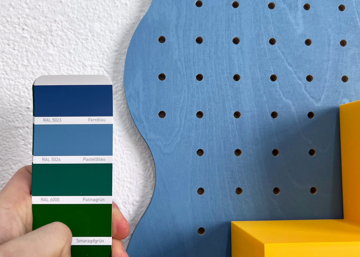 Nuancier de couleurs devant un pegboard bleu sur mesure