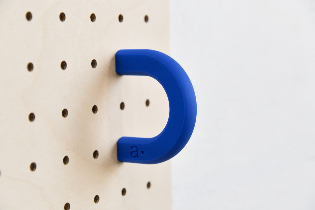 Anneau coloré bleu taille M sur un pegboard en bouleau