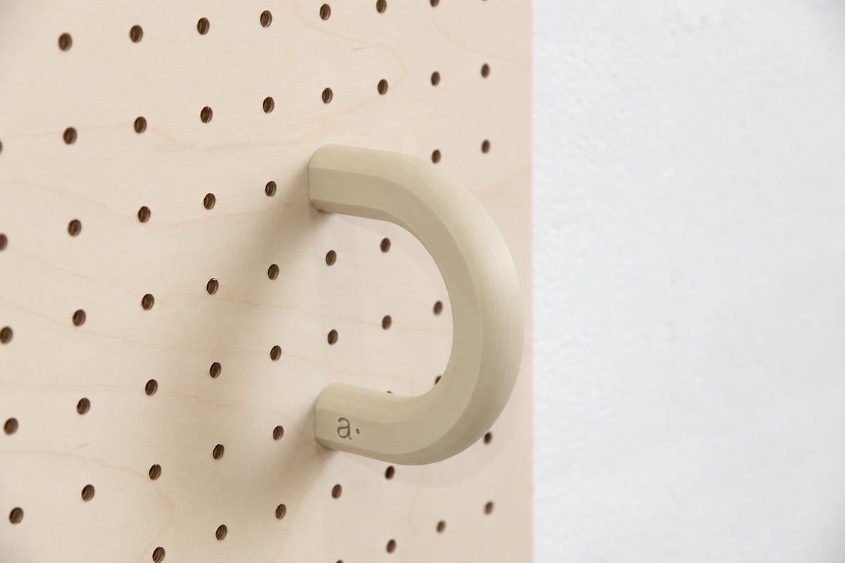 Anneau coloré beige taille L sur un pegboard en bouleau