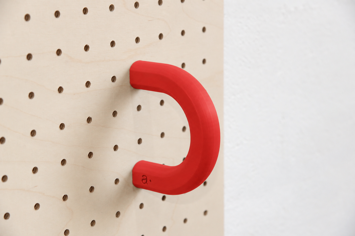Anneau coloré rouge taille L sur un pegboard en bouleau