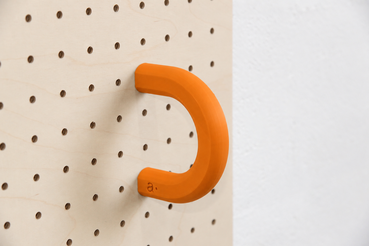 Anneau coloré orange taille L sur un pegboard en bouleau