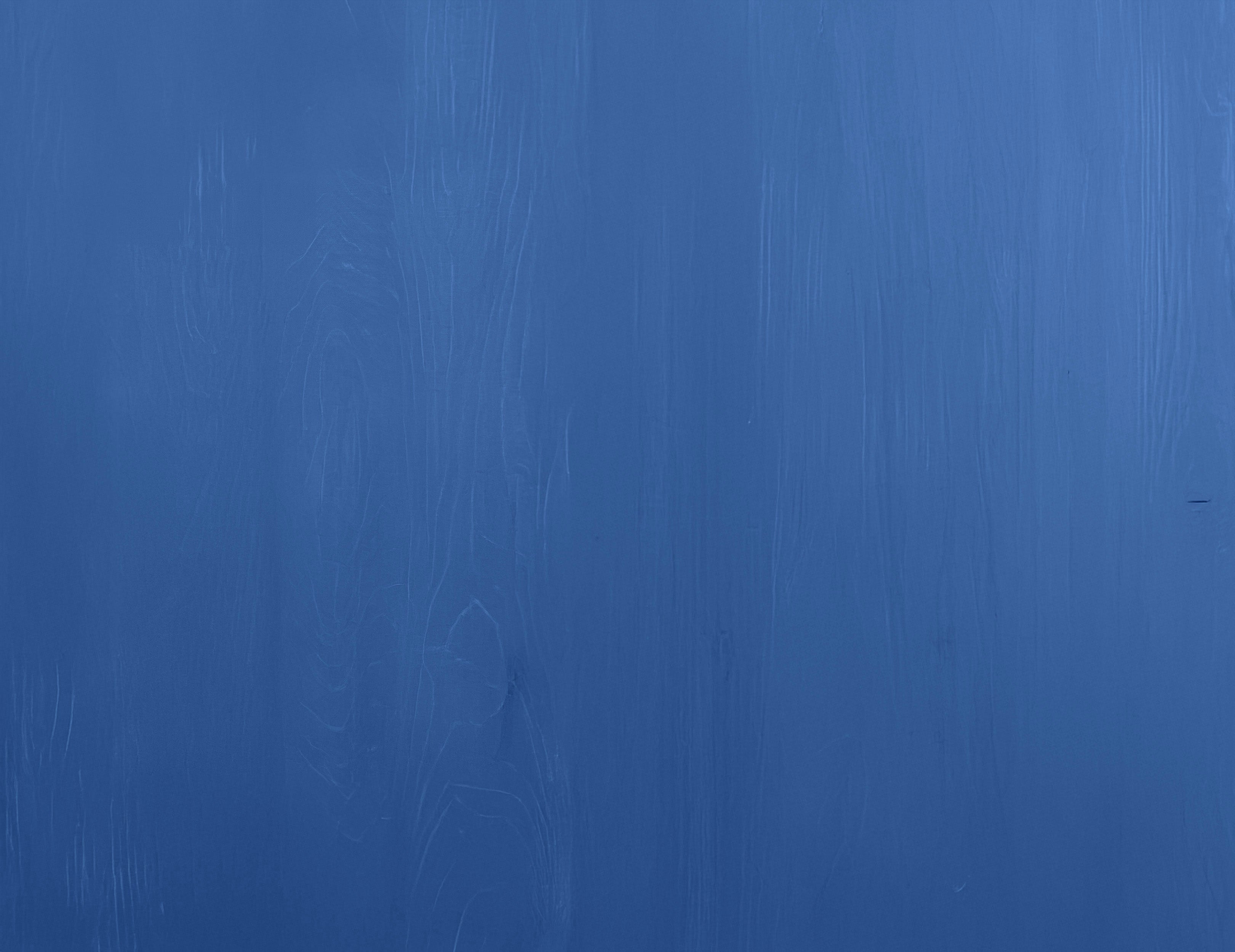 Smooth blue painted wooden surface with subtle natural grain texture in a stylish finish