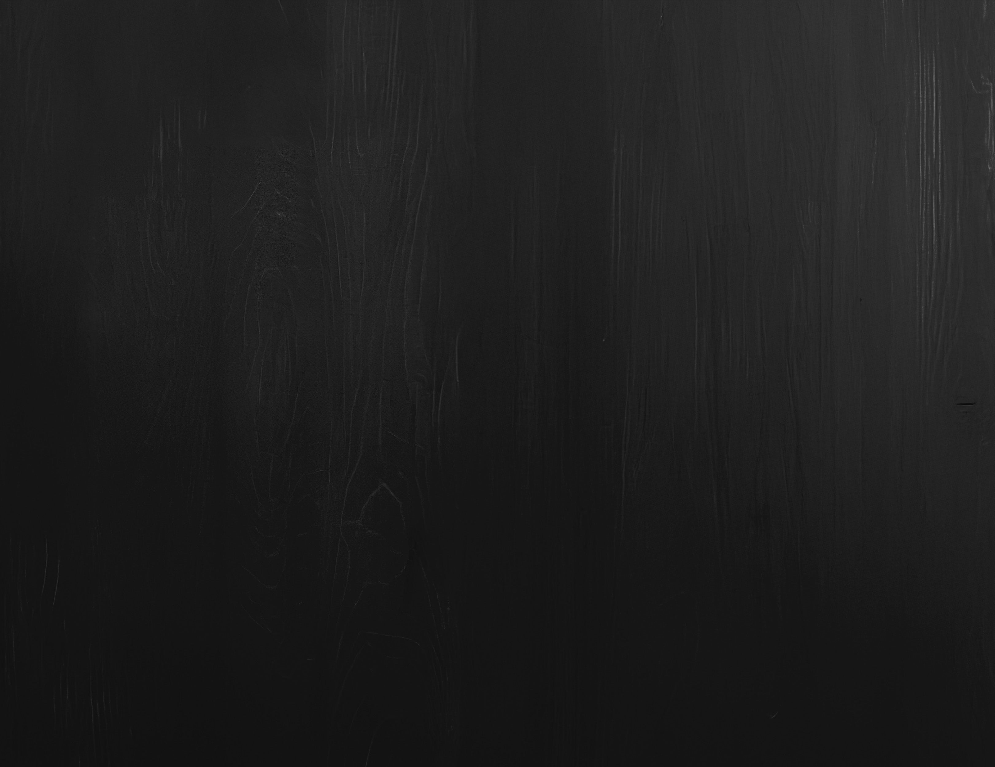 Dark black wooden surface with subtle wood grain texture and natural patterns visible