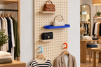 Pegboard shop display with coloured rings for hangers and handbags