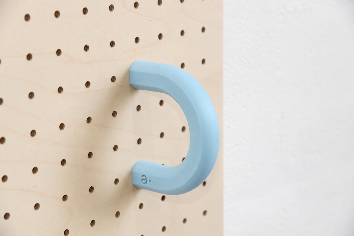 Anilla de color azul cielo talla L en un pegboard de abedul