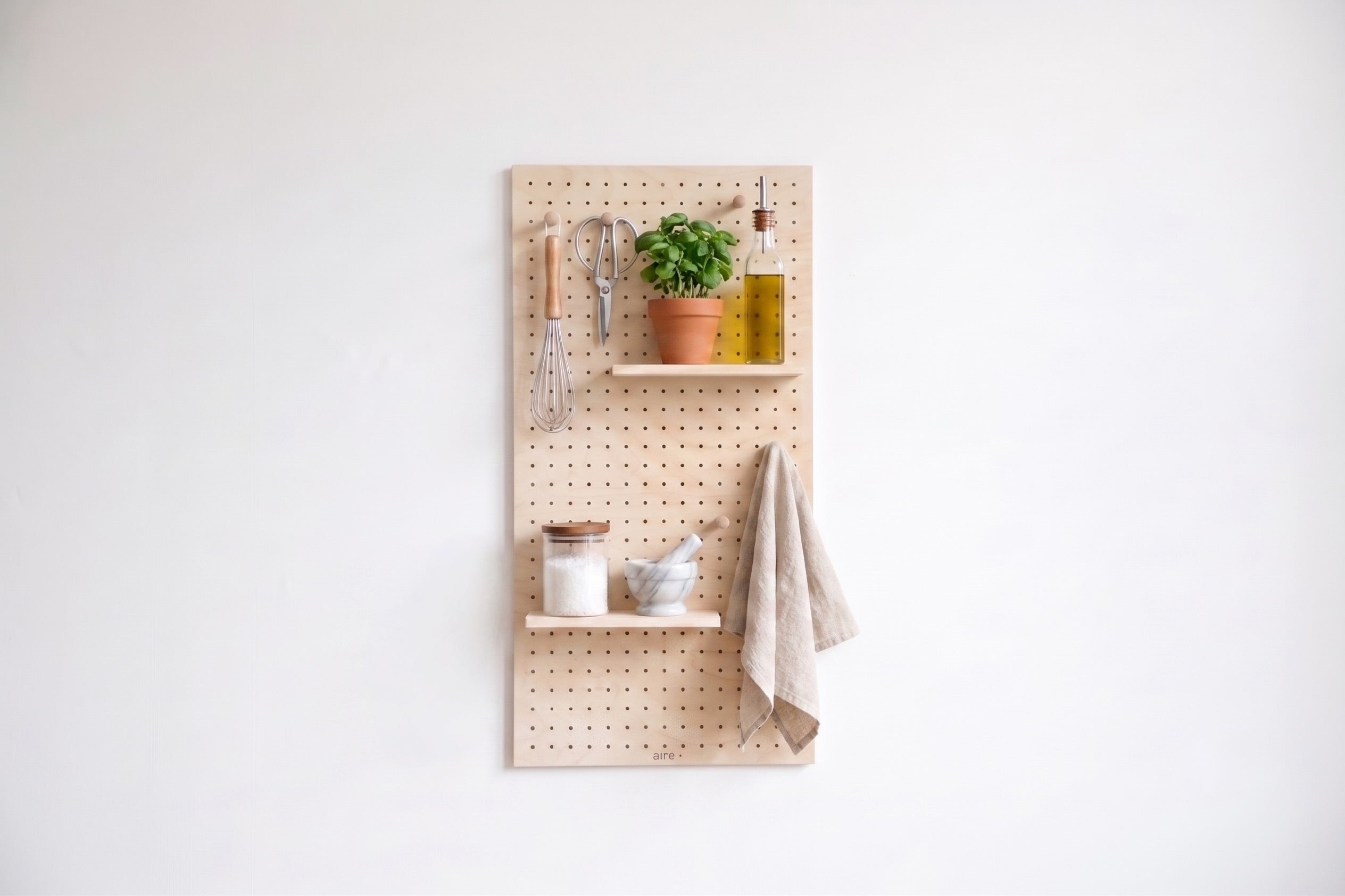 Pegboard aire en cuisine avec ustensiles et plantes aromatiques