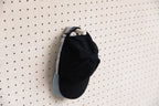 Zwei übereinander hängende Caps am Aire Wand-Cap-Halter für Pegboard