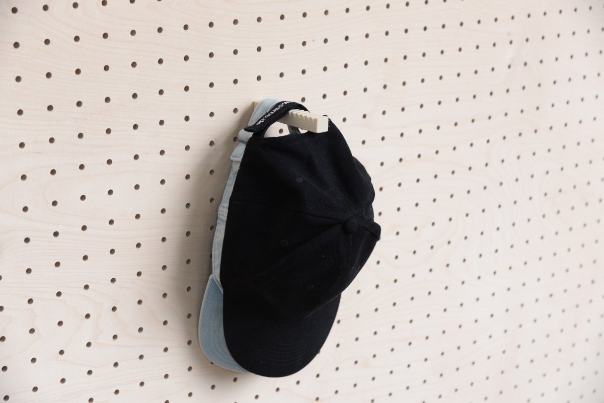 Zwei übereinander hängende Caps am Aire Wand-Cap-Halter für Pegboard