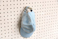 Wand-Cap-Halter für die Lochwand mit einer blauen Cap